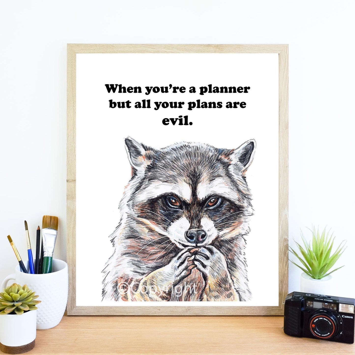Crayon drawing of raccoon who is planning his next evil scheme. Art by Deidre Wicks