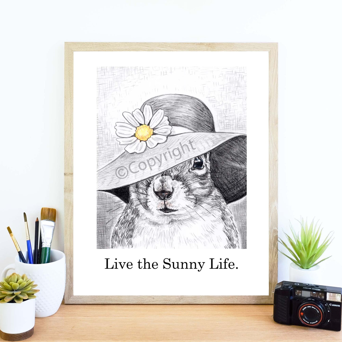 Crayon drawing of a squirrel wearing a big floppy sun hat with a daisy on the brim. Art by Deidre Wicks