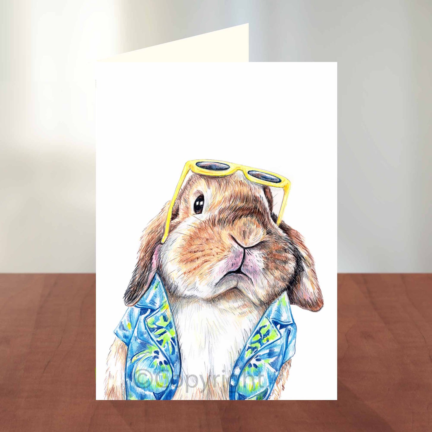 Blank greeting card featuring a lop eared bunny rabbit wearing a Hawaiian shirt. Art by Deidre Wicks