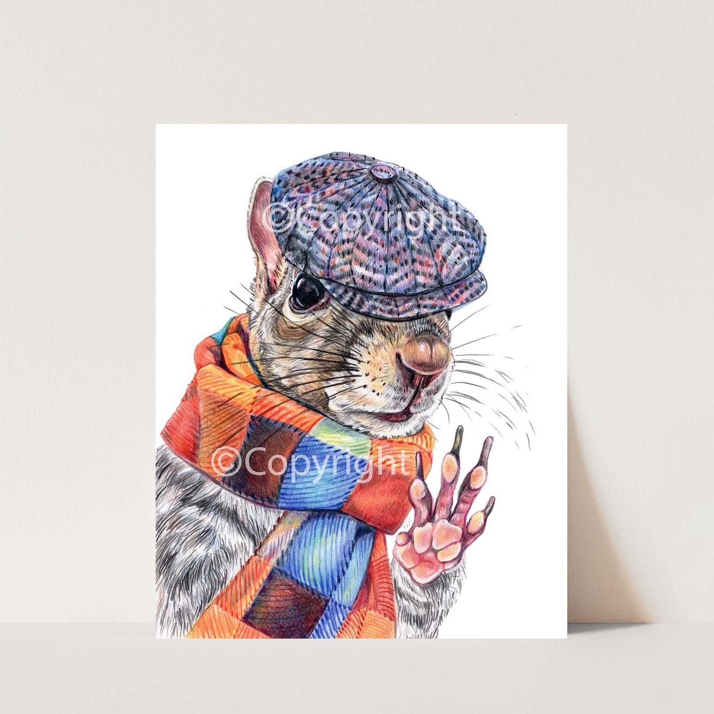 Coloured pencil drawing of a dapper Eastern grey squirrel wearing a newsboy hat and wool scarf. Art by Deidre Wicks