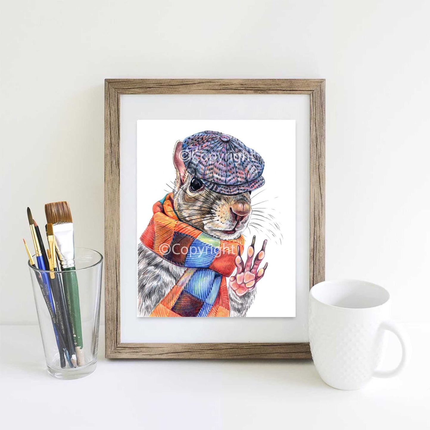 Coloured pencil drawing of a dapper Eastern grey squirrel wearing a newsboy hat and wool scarf. Art by Deidre Wicks