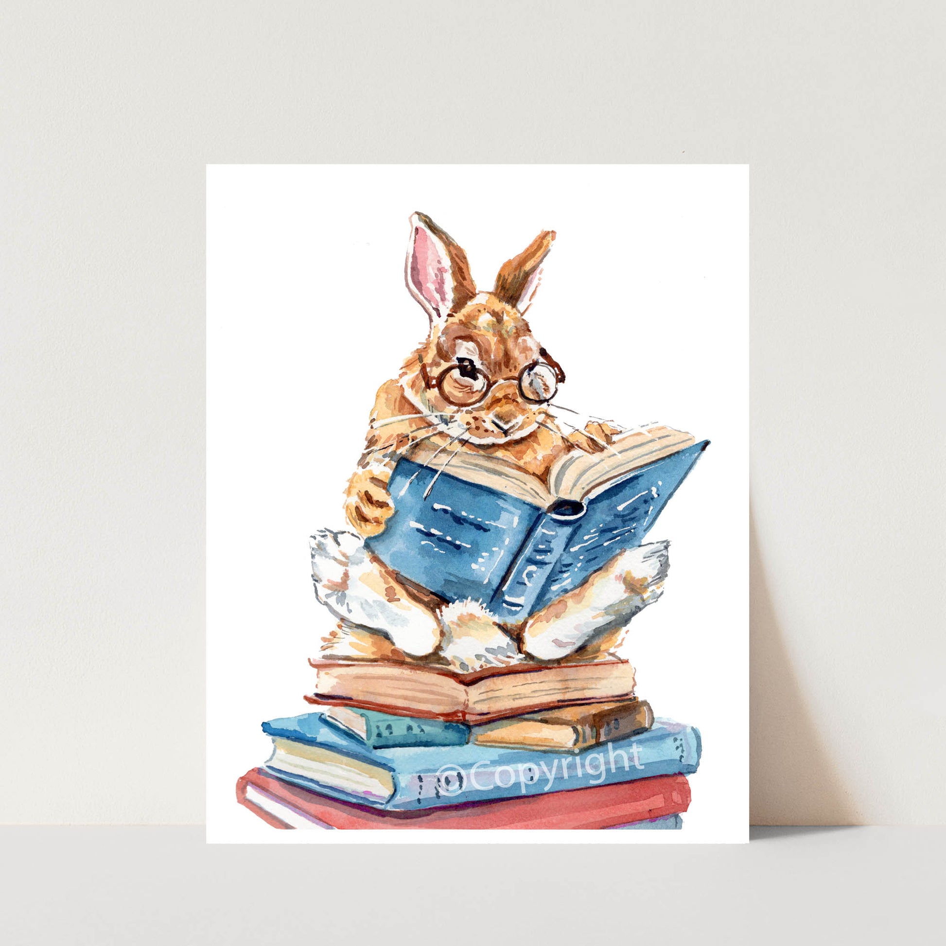 Illustration of a rabbit wearing glasses and reading a book on a stack of books.