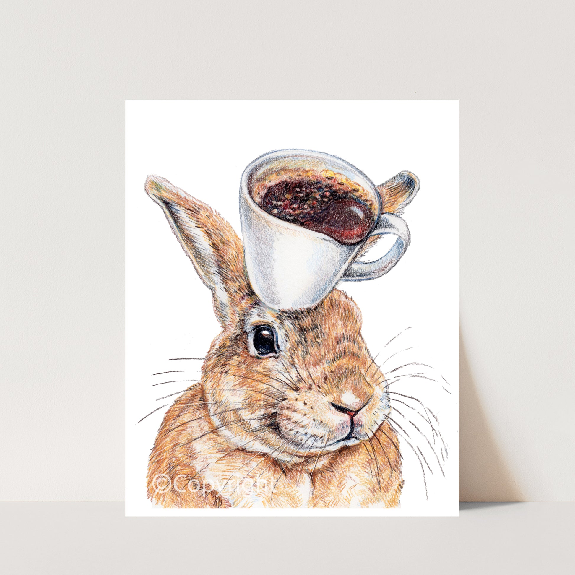 Coloured pencil drawing of a happy rabbit balancing a coffee cup on his head. Art by Deidre WIcks