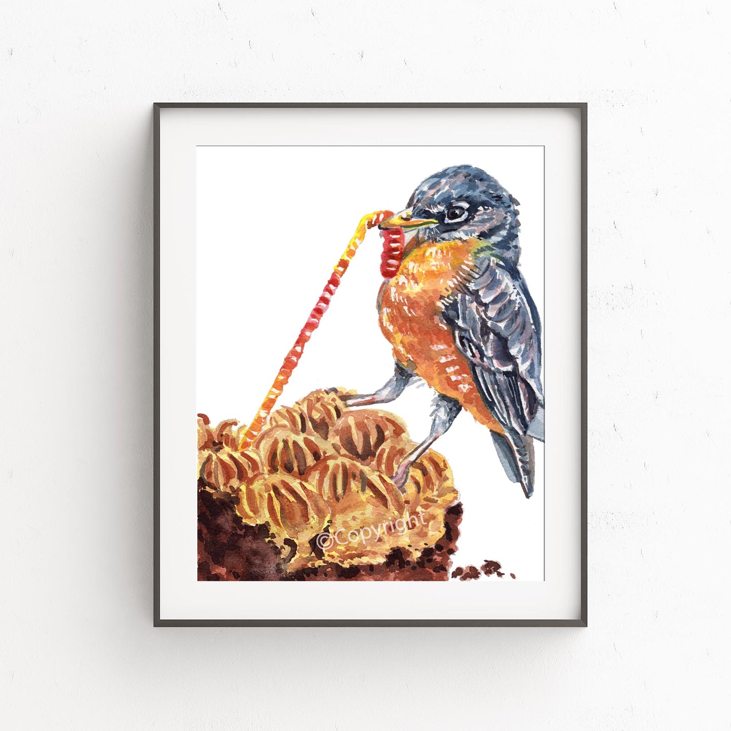 Watercolour painting of a robin pulling a gummy worm from a piece of cake