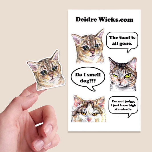 Cat-themed stickers with speech bubbles and a hand holding one of them.