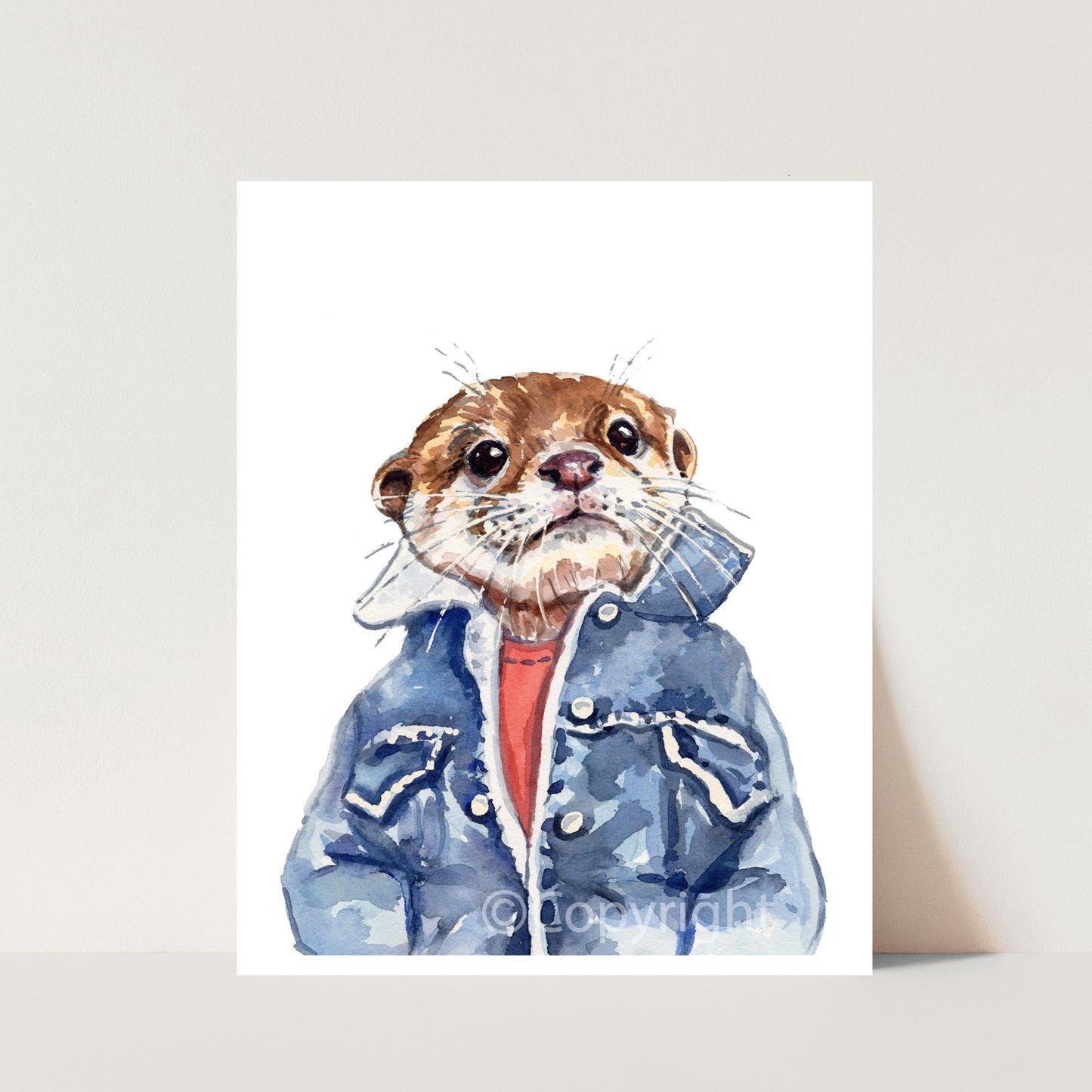 A watercolor painting of an otter wearing a blue denim jacket and red shirt, displayed against a light beige background.