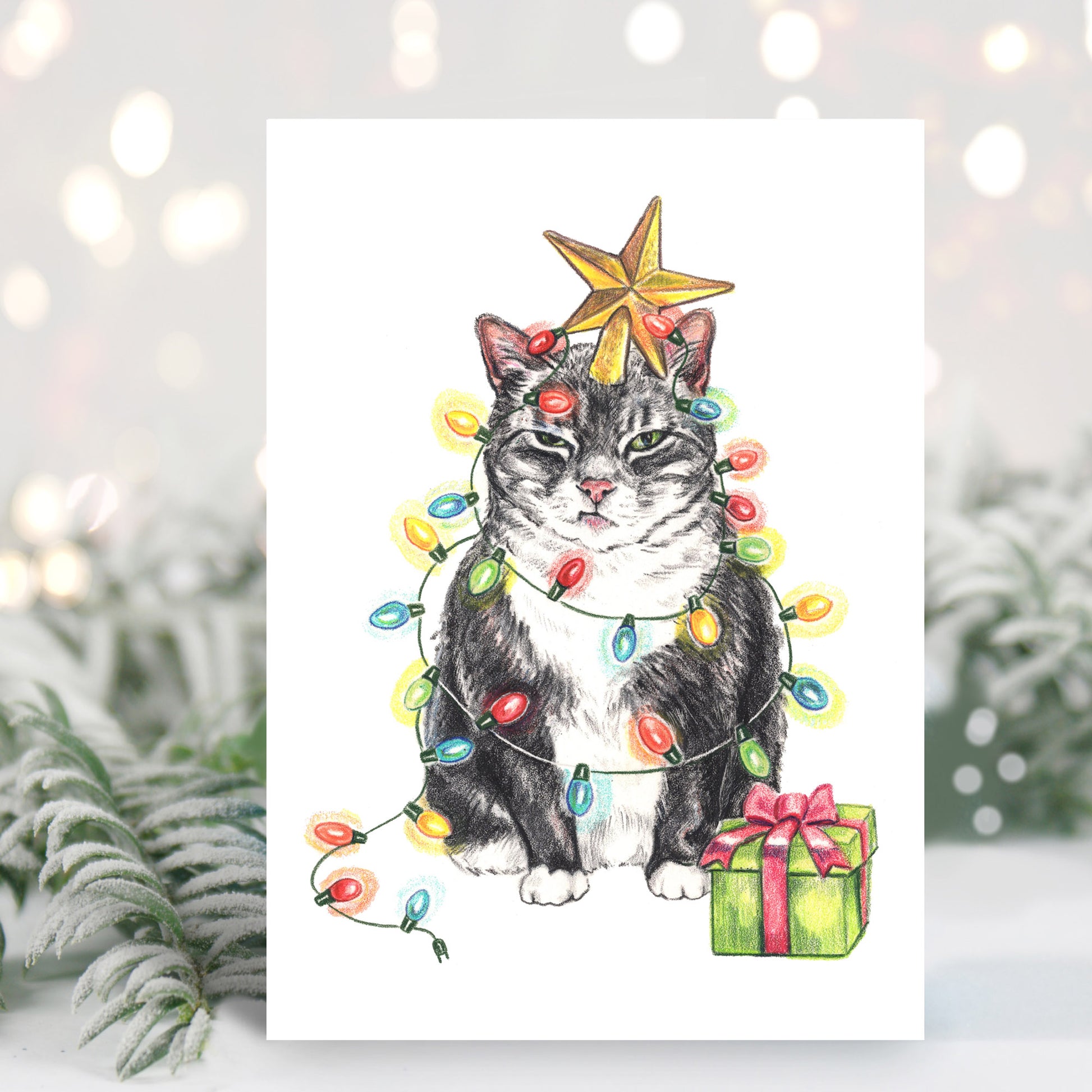 Christmas card featuring a crayon drawing of a grumpy tuxedo cat wrapped in lights like a Christmas tree