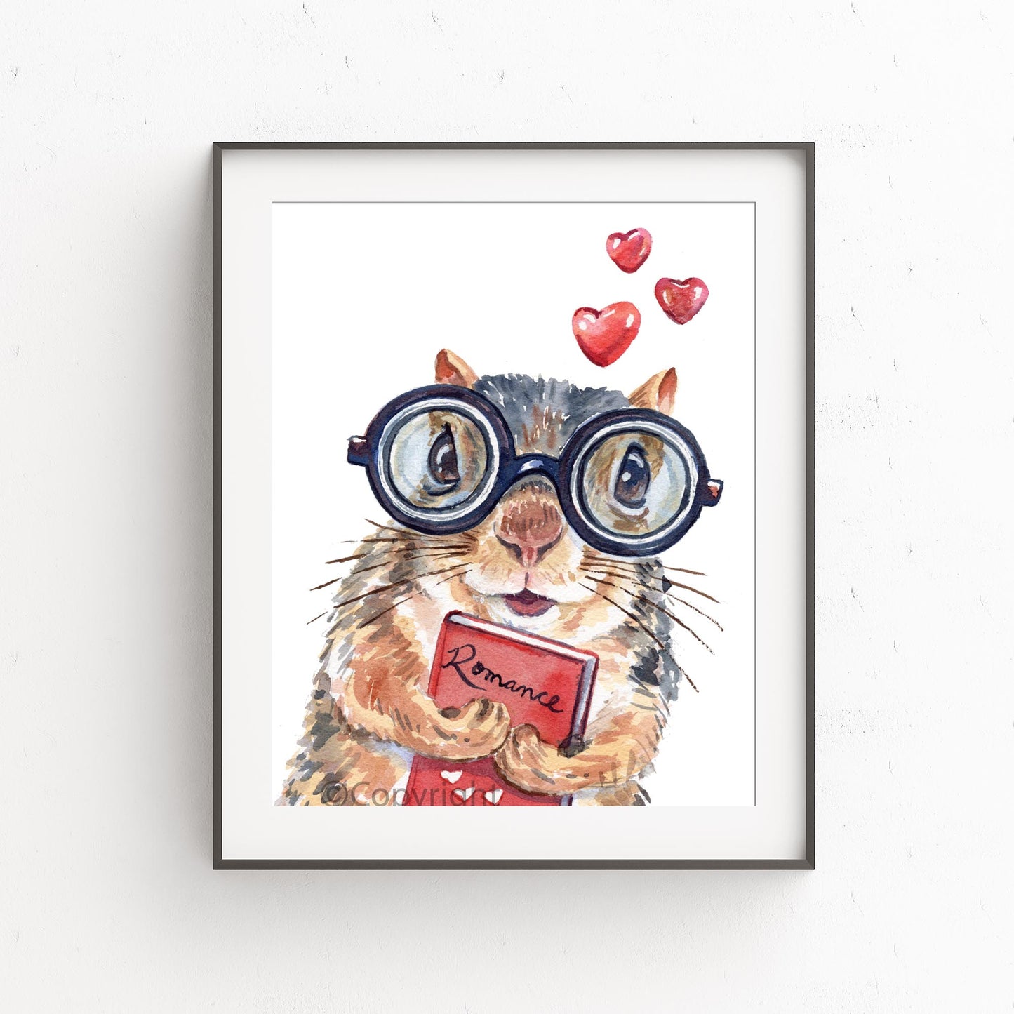 Framed artwork of a squirrel wearing glasses with heart symbols and a 'Romance' book.