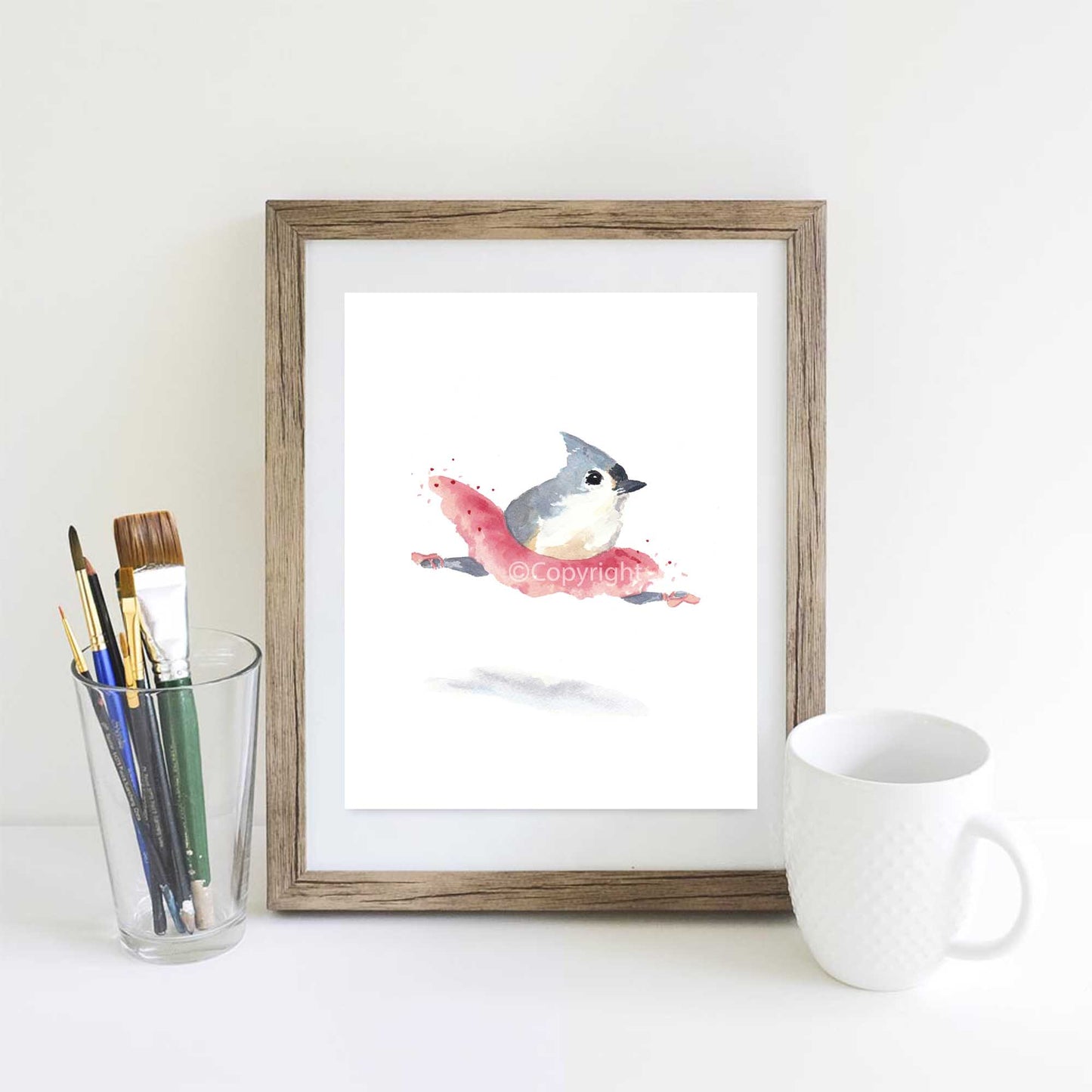 Watercolour of a leaping titmouse ballerina bird wearing a pink tutu and pointe shoes. Art by Deidre Wicks