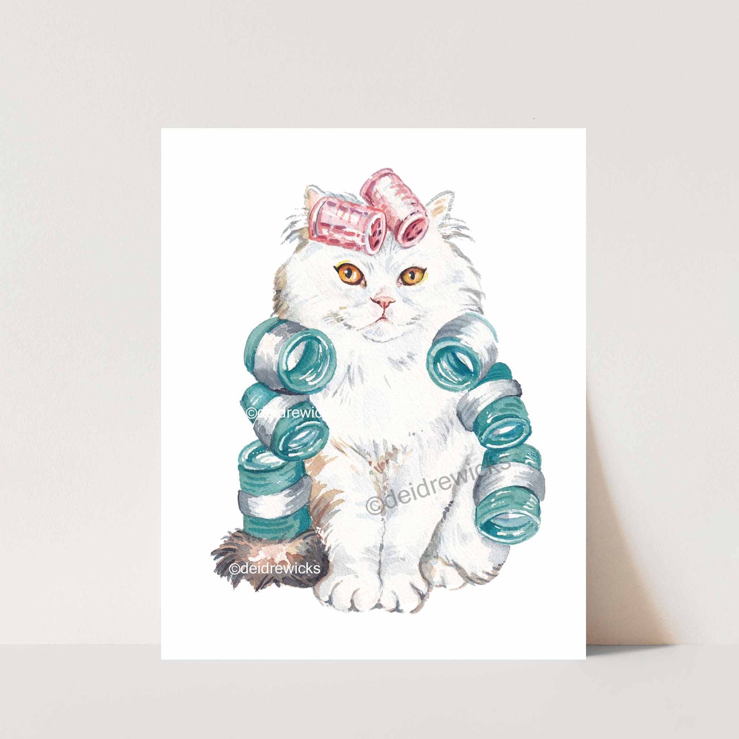 Cat watercolour featuring a white Persian cat wearing brightly coloured hair curlers. Art by Deidre Wicks