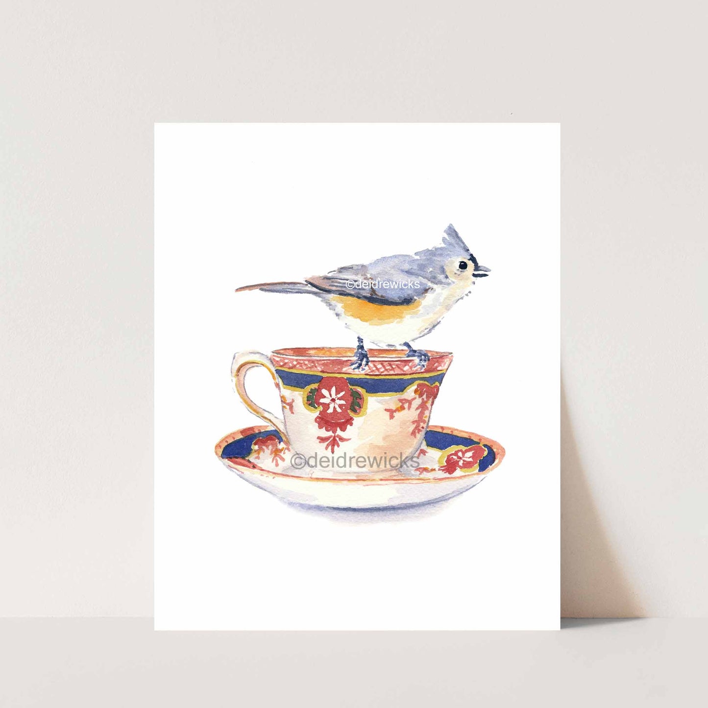Watercolour painting of a titmouse bird perched on the edge of a tea cup by artist Deidre Wicks