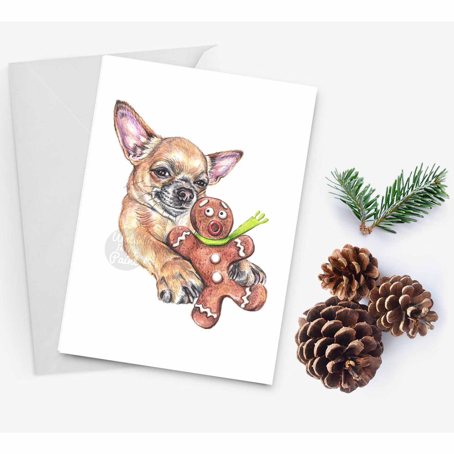 Dog themed Christmas card featuring a chihuahua who is just ''holding'' a gingerbread man. Art by Deidre Wicks