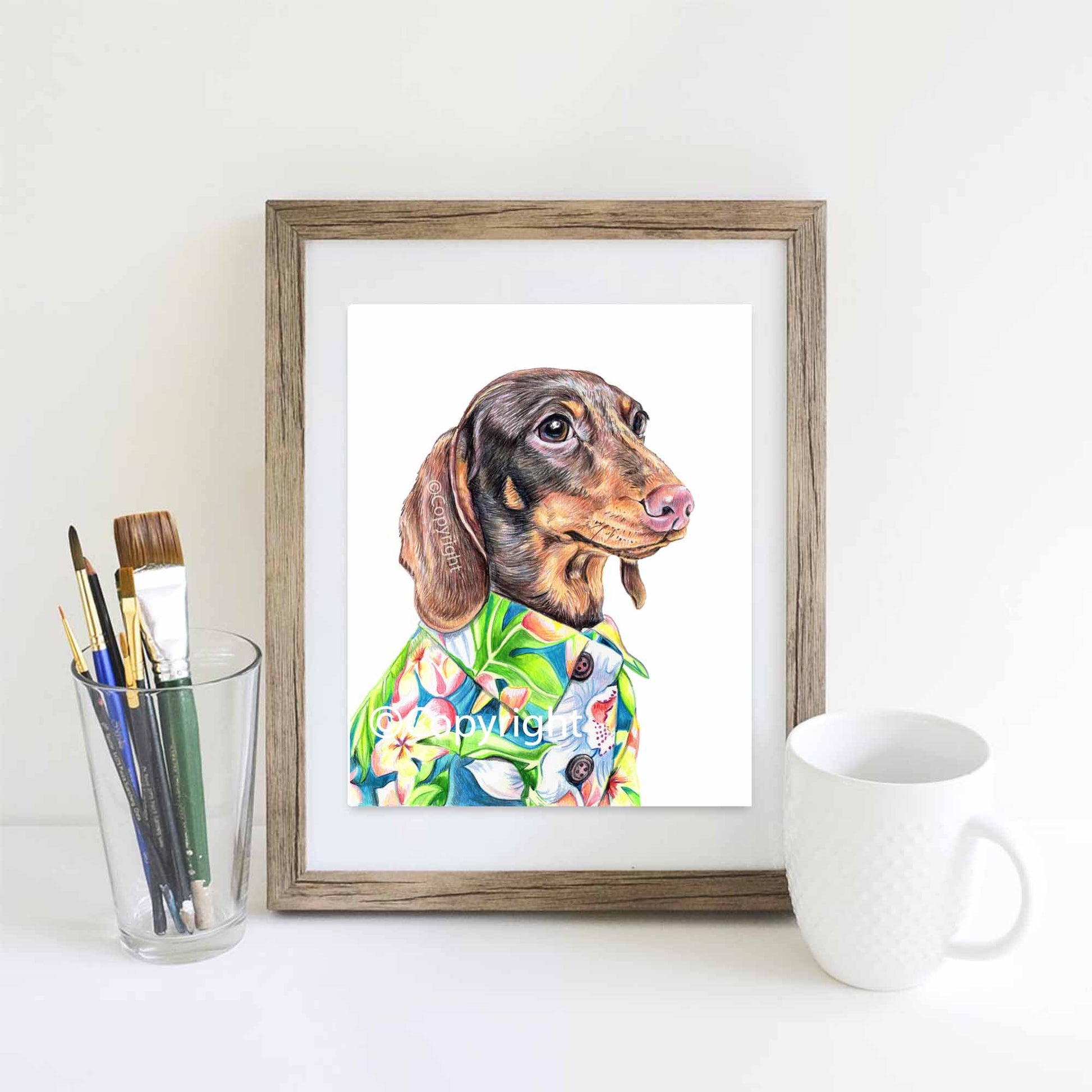 Coloured pencil drawing of a dachshund dog wearing a bright green and blue Hawaiian shirt. Art by Deidre Wicks
