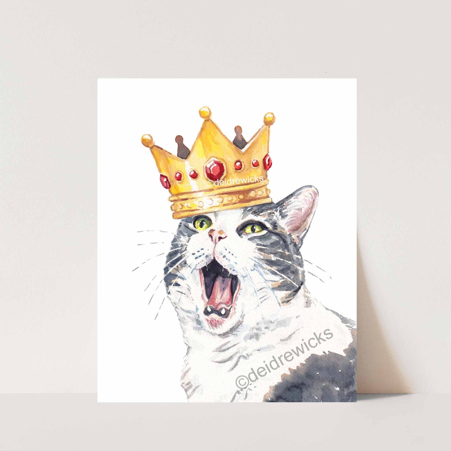 Watercolor print of a grumpy grey tabby cat wearing a royal gold crown. Original art by Deidre Wicks