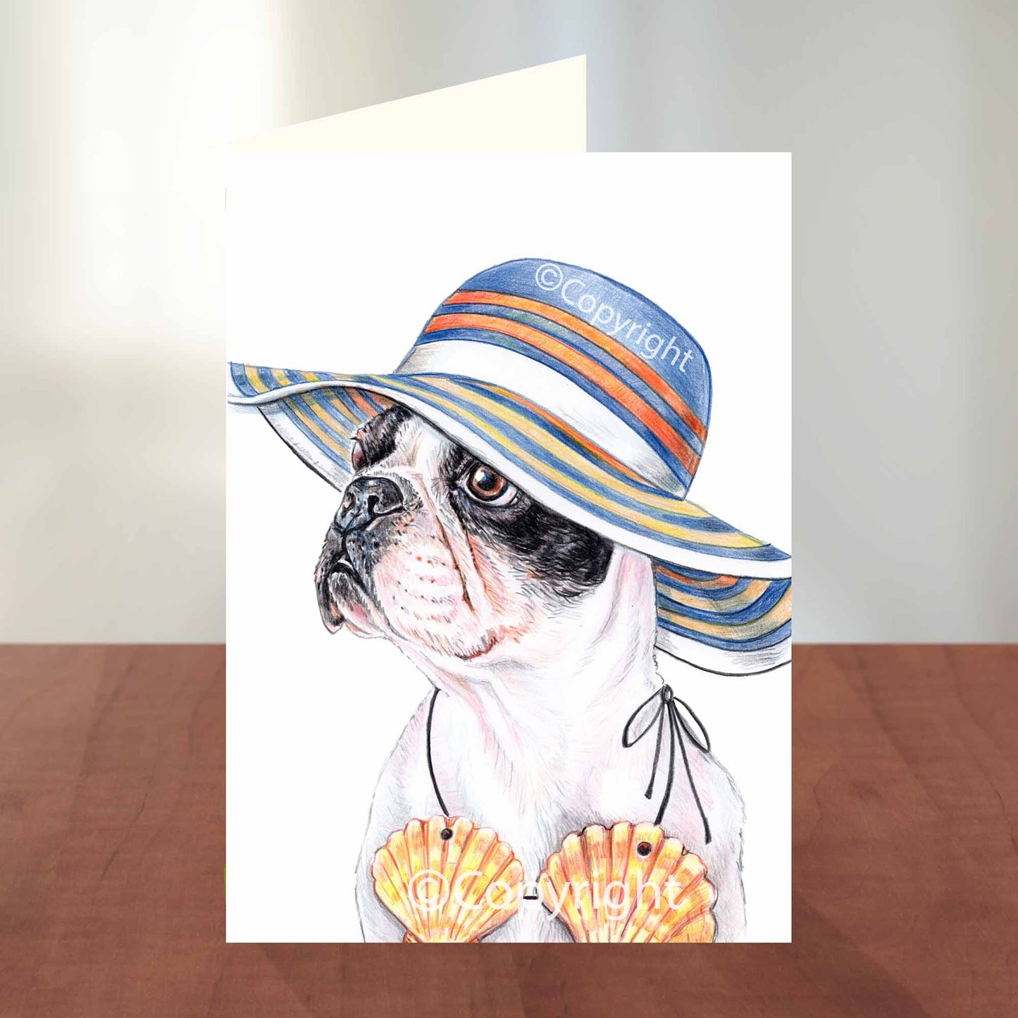 Blank greeting card featuring a drawing of a Boston Terrier dog wearing a summer hat and sea shell bikini top. Art by Deidre Wicks
